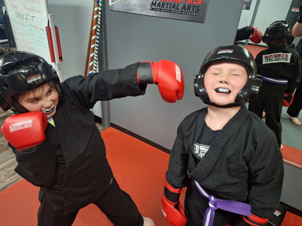 Children doing partner martial arts drills in Fenton