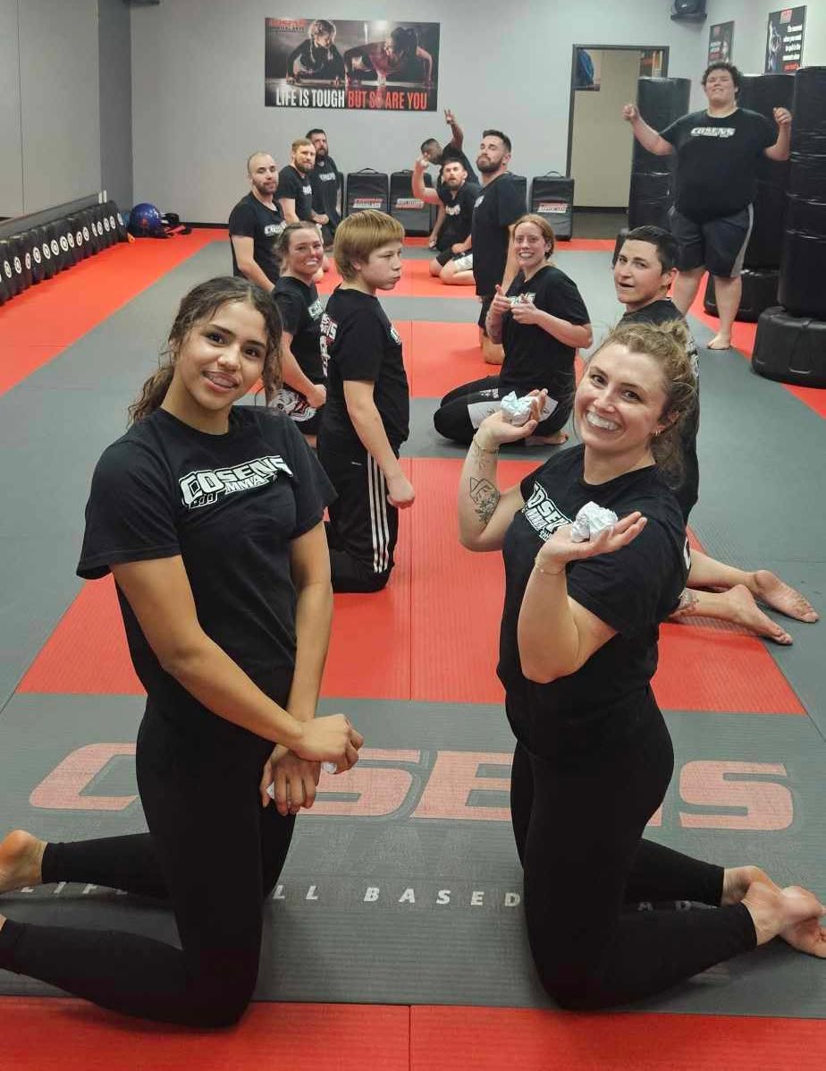 Women and men smiling together during adult MMA training